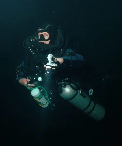 Rebreather diver with bailout rebreather diving deep in the cave